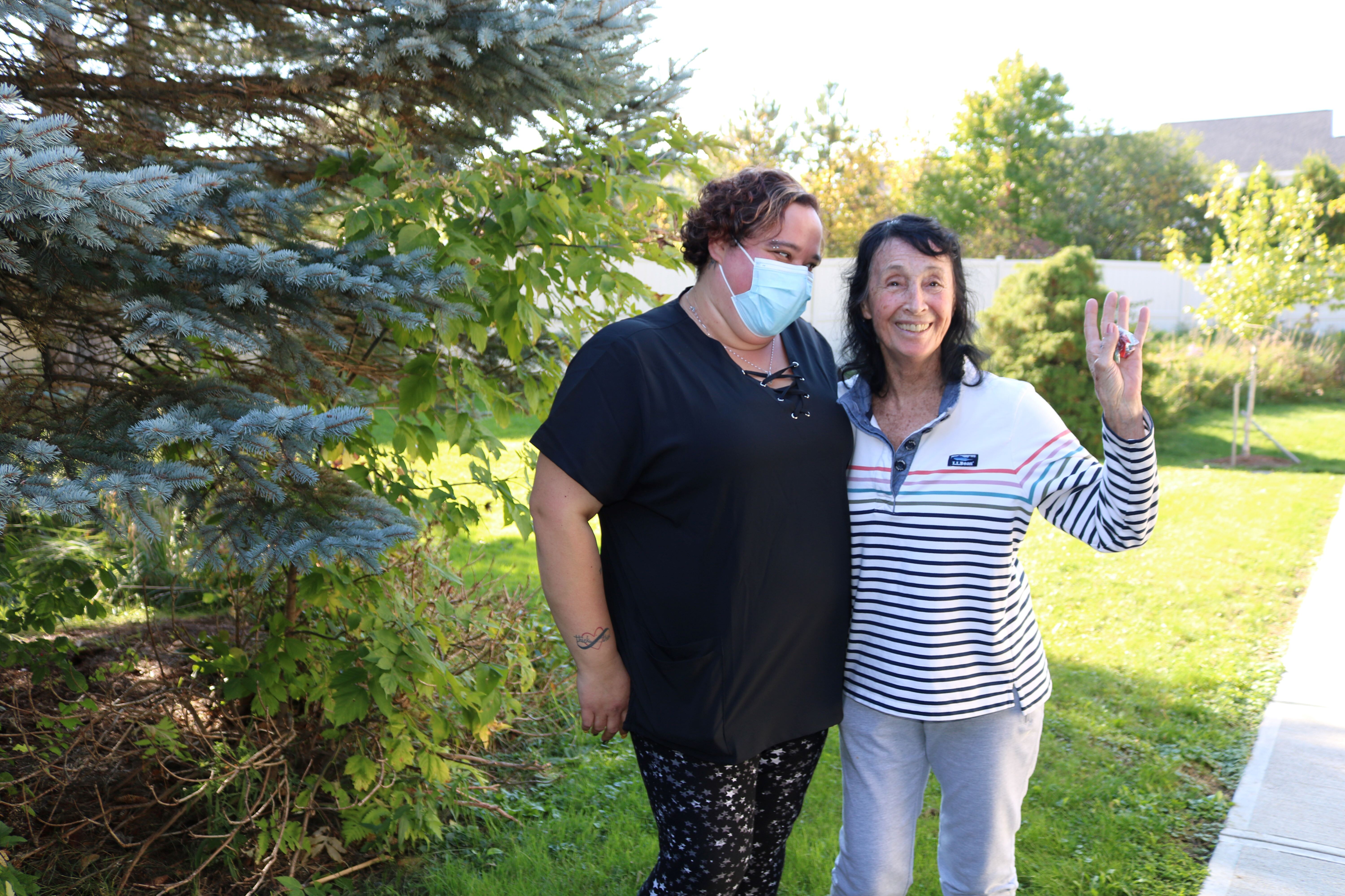 Bethany LeBlanc, a licensed nursing assistant at Allen Brook, spends time outside with her friend and resident Janet