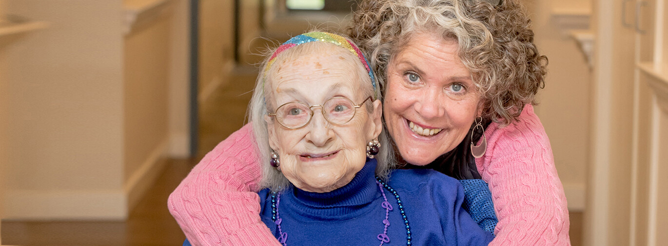Photo of caregiver embracing memory care resident
