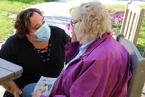 Licensed Practical Nurse Bethany LeBlanc chats with an Allen Brook resident in the garden.